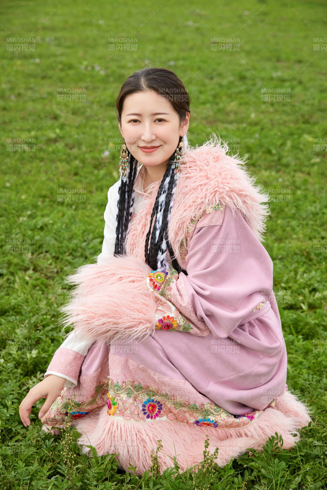 身穿粉色藏族服饰在草原拍照的少女图片