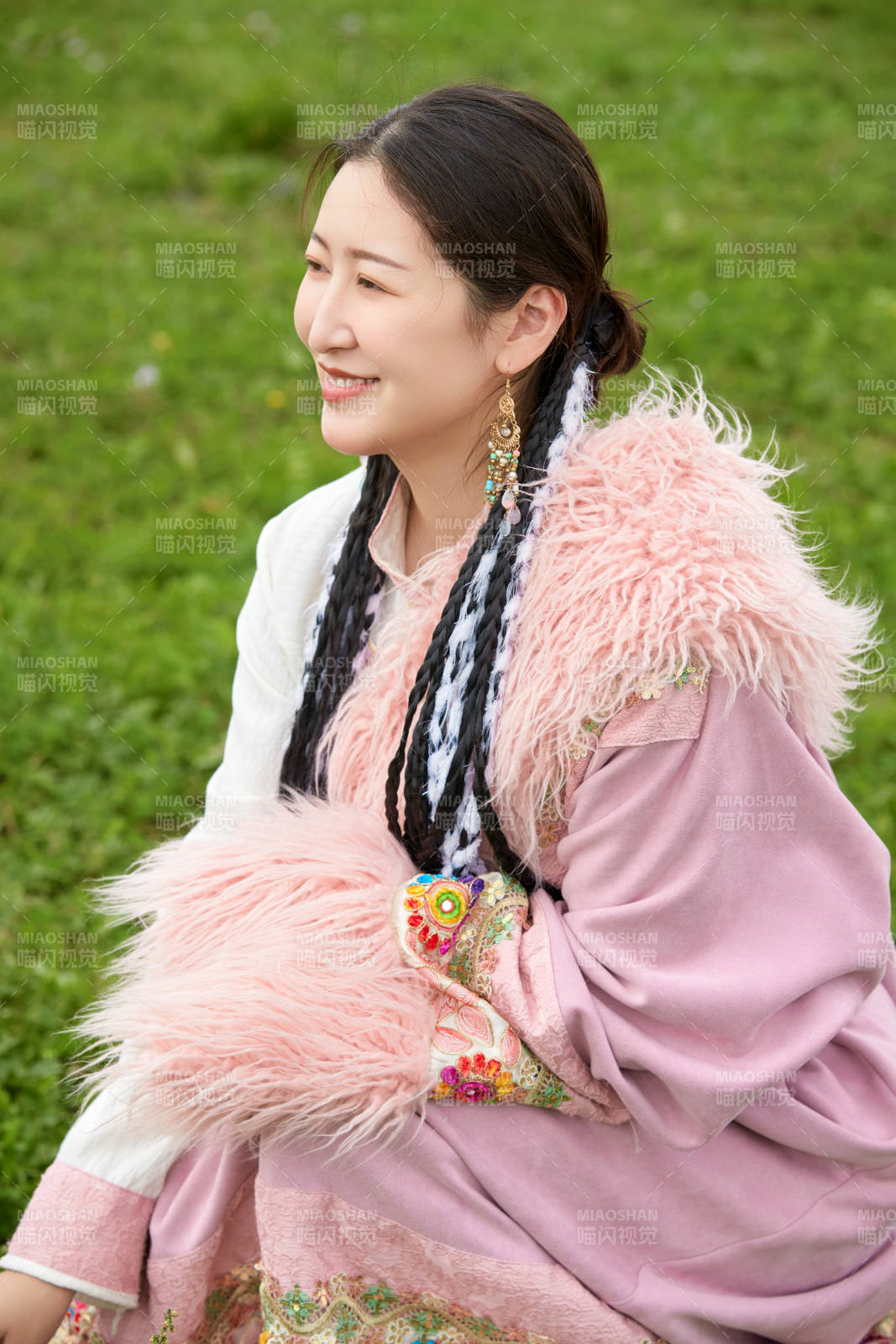 身穿粉色藏族服饰在草原拍照的少女图片