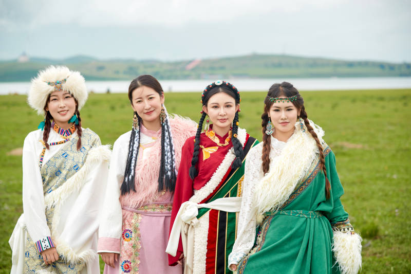 穿藏族服饰在草原拍照游玩的姑娘们图片