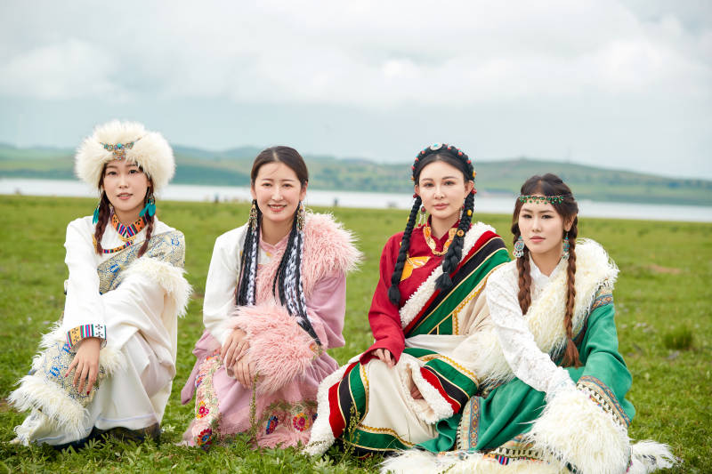 穿藏族服饰在草原拍照游玩的姑娘们图片
