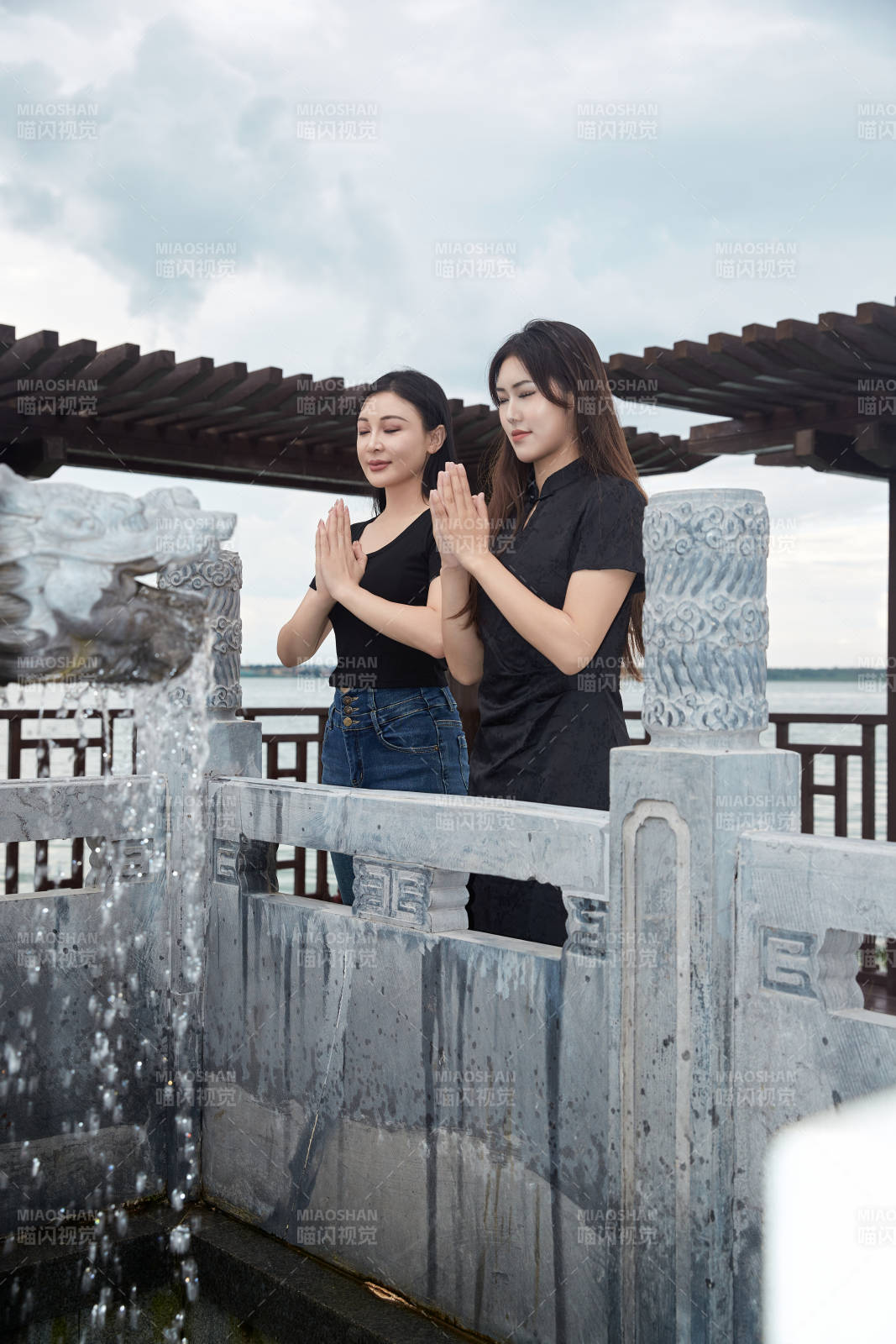 盛夏在景区湖边许愿井祈福的美女图片