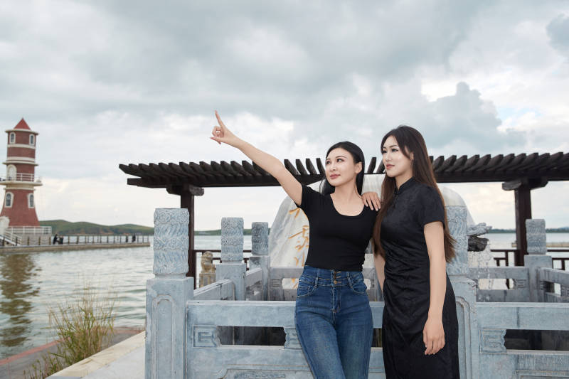 盛夏在景区湖边许愿井祈福的美女图片