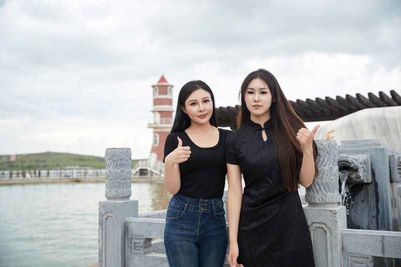 盛夏在景区湖边许愿井祈福的美女图片