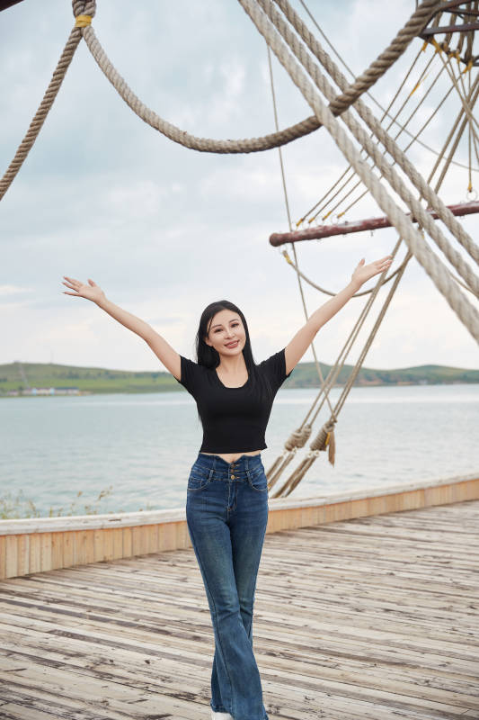 在湖畔木制帆船上拍照游玩的亚洲女性图片