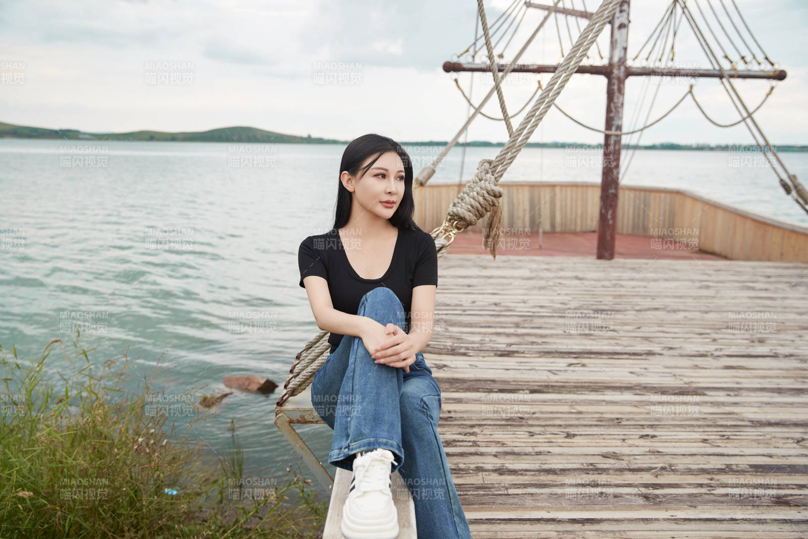 在湖畔木制帆船上拍照游玩的亚洲女性图片