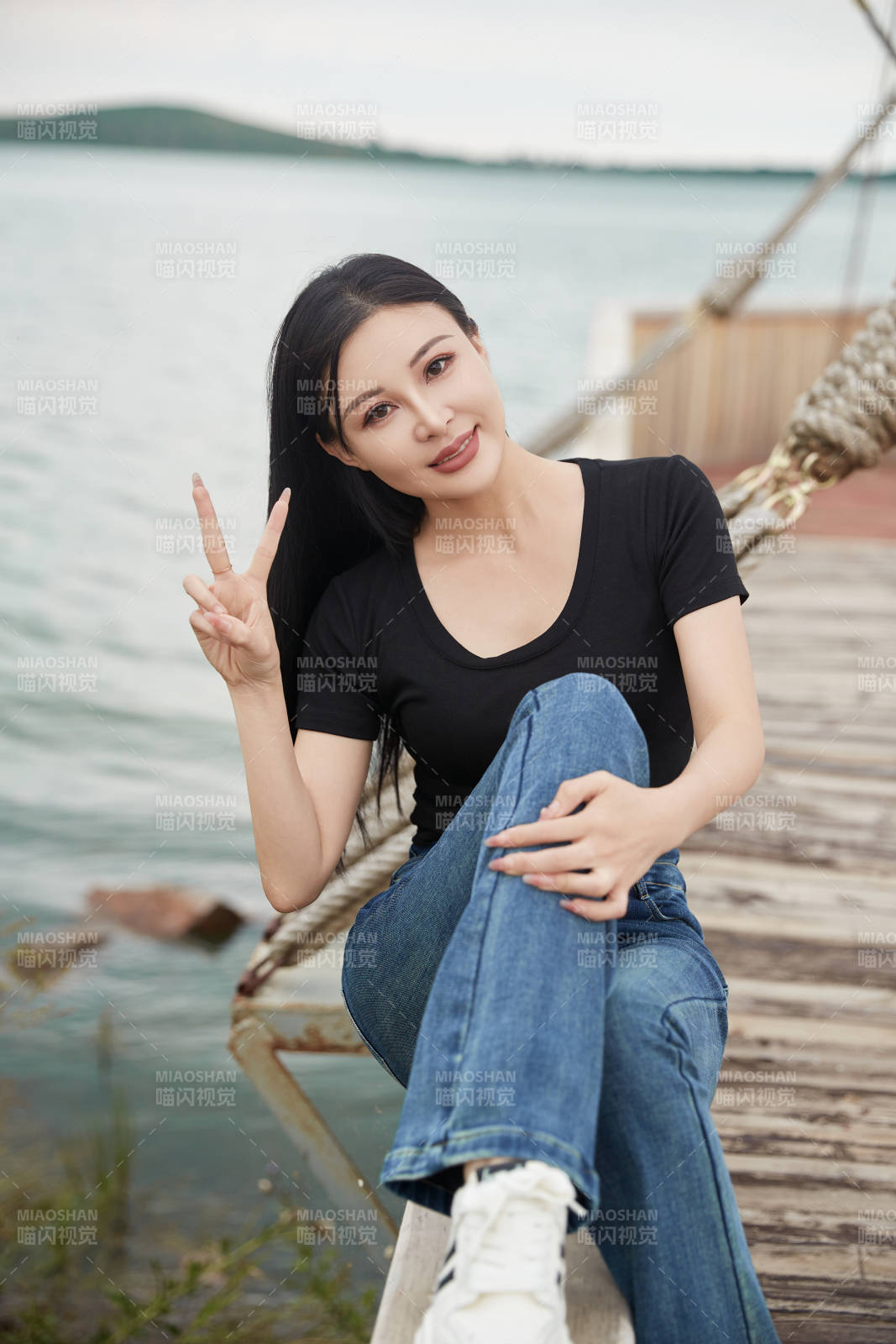 在湖畔木制帆船上拍照游玩的亚洲女性图片