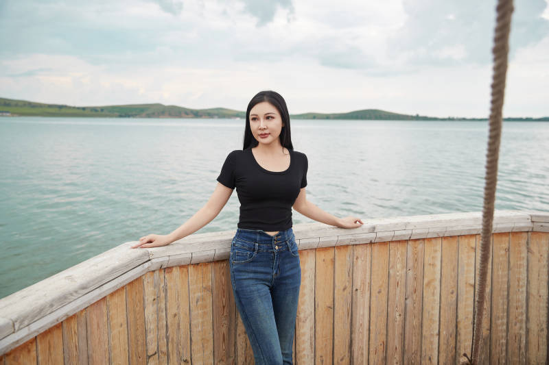 在湖畔木制帆船上拍照游玩的亚洲女性图片