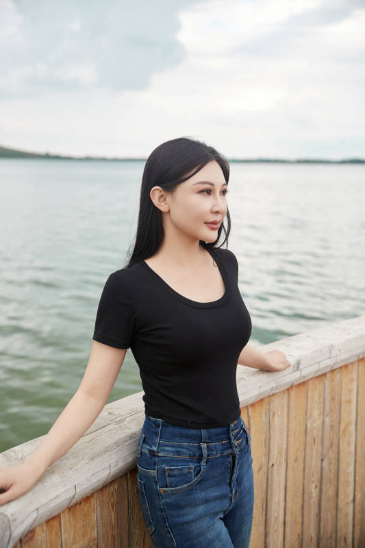 在湖畔木制帆船上拍照游玩的亚洲女性图片