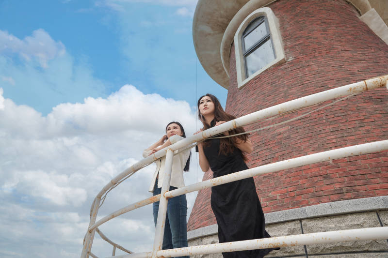 在旅游区湖边打卡点拍照的美女闺蜜图片