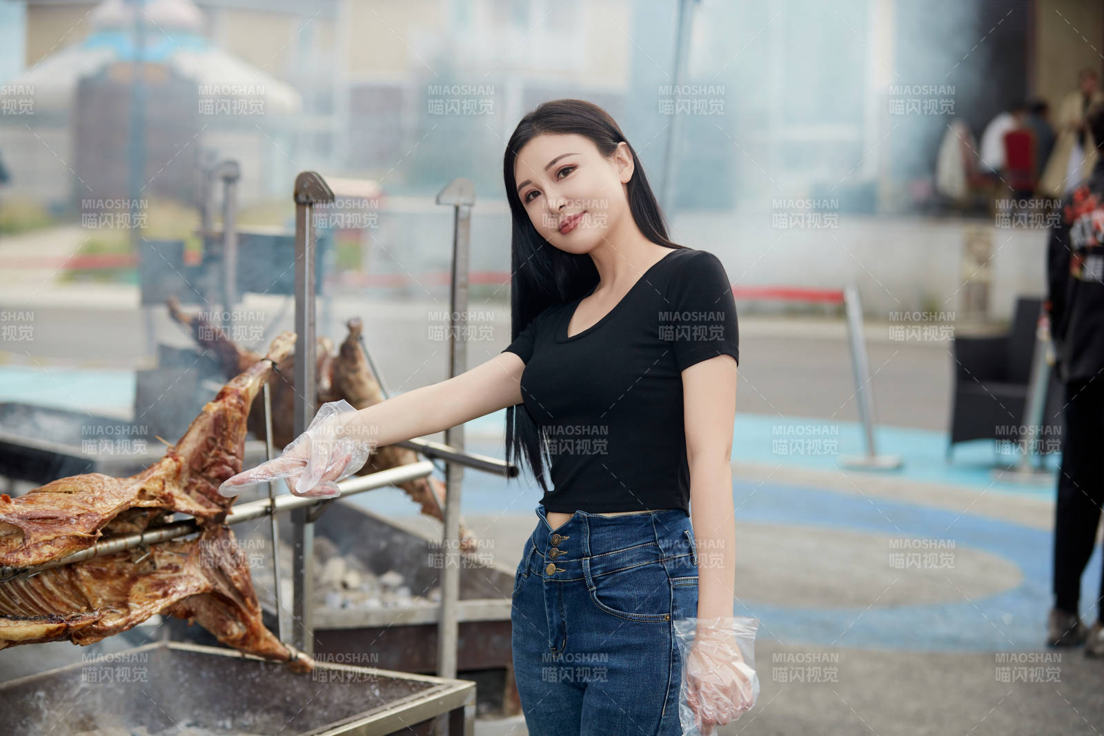在户外烤全羊自助餐会品尝美食的美女图片