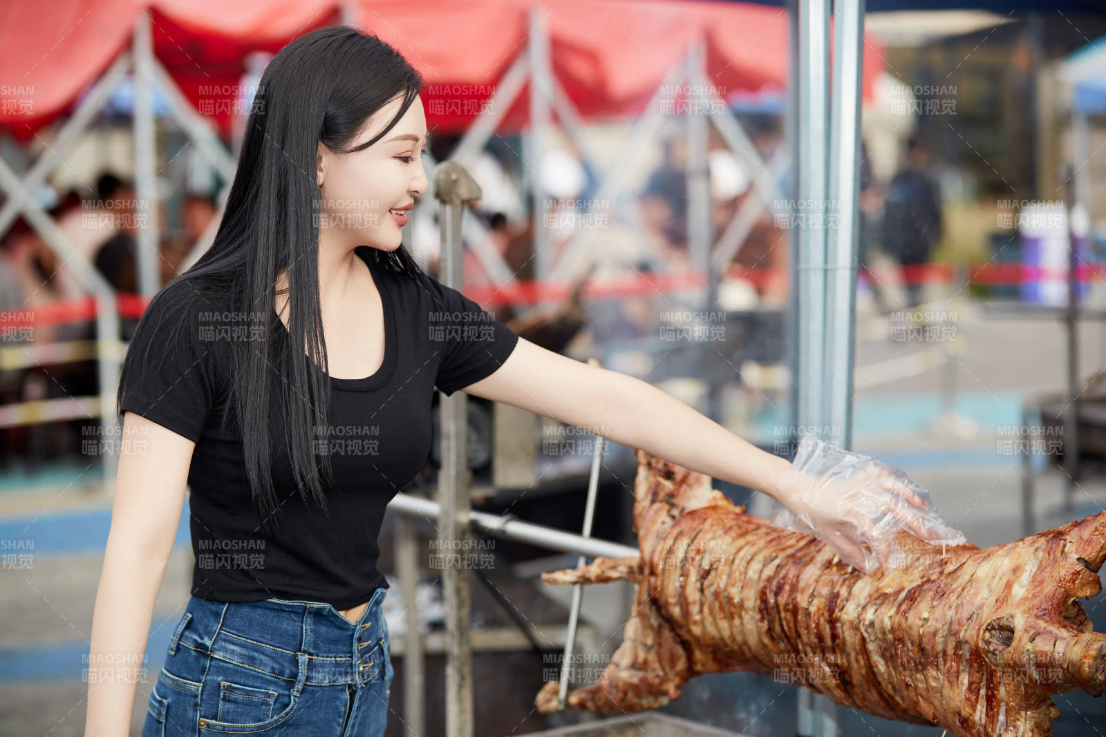 在户外烤全羊自助餐会品尝美食的美女图片