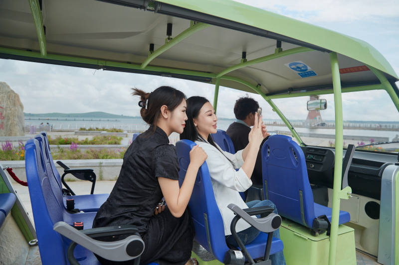自驾旅游观光车在景区游玩的两位姑娘图片