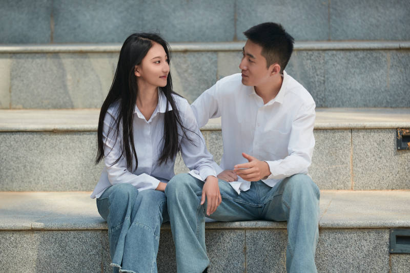 坐在户外台阶上的青年情侣图片