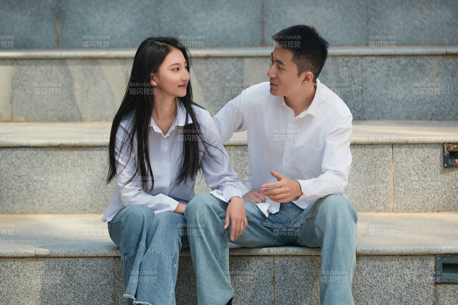 坐在户外台阶上的青年情侣图片