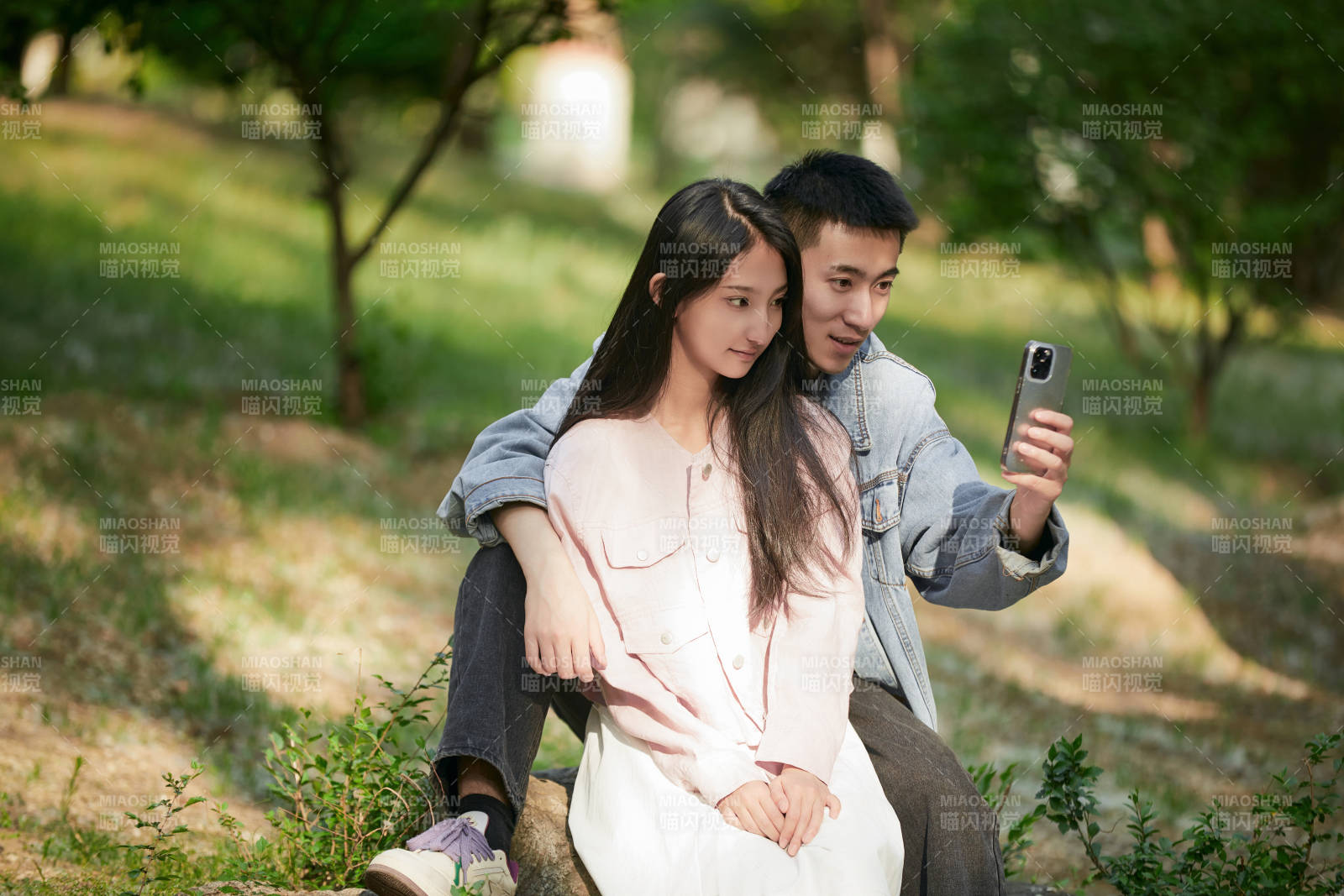 户外公园里用手机自拍的年轻情侣图片