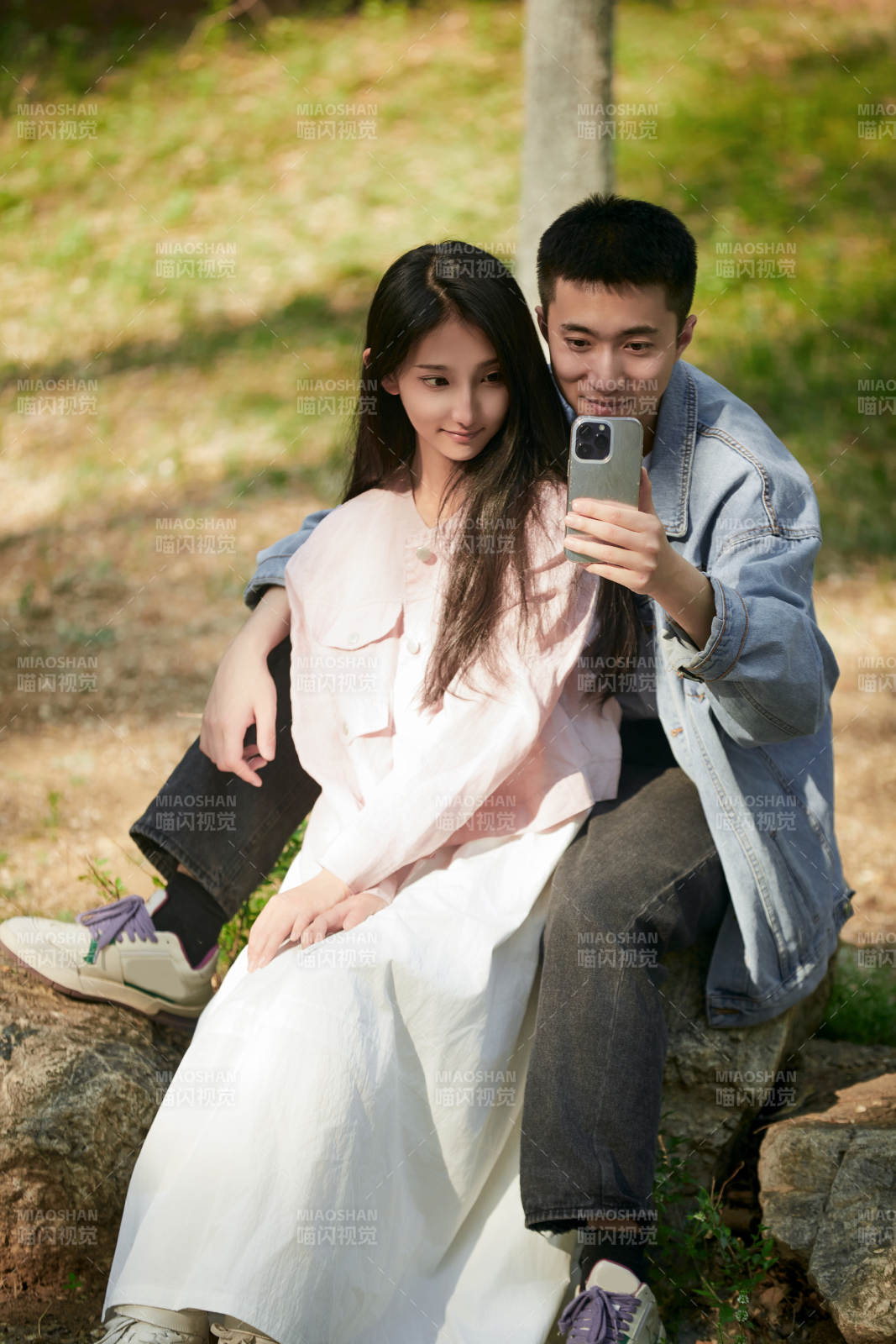户外公园里用手机自拍的年轻情侣图片