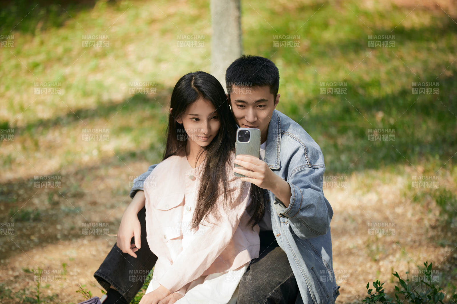户外公园里用手机自拍的年轻情侣图片