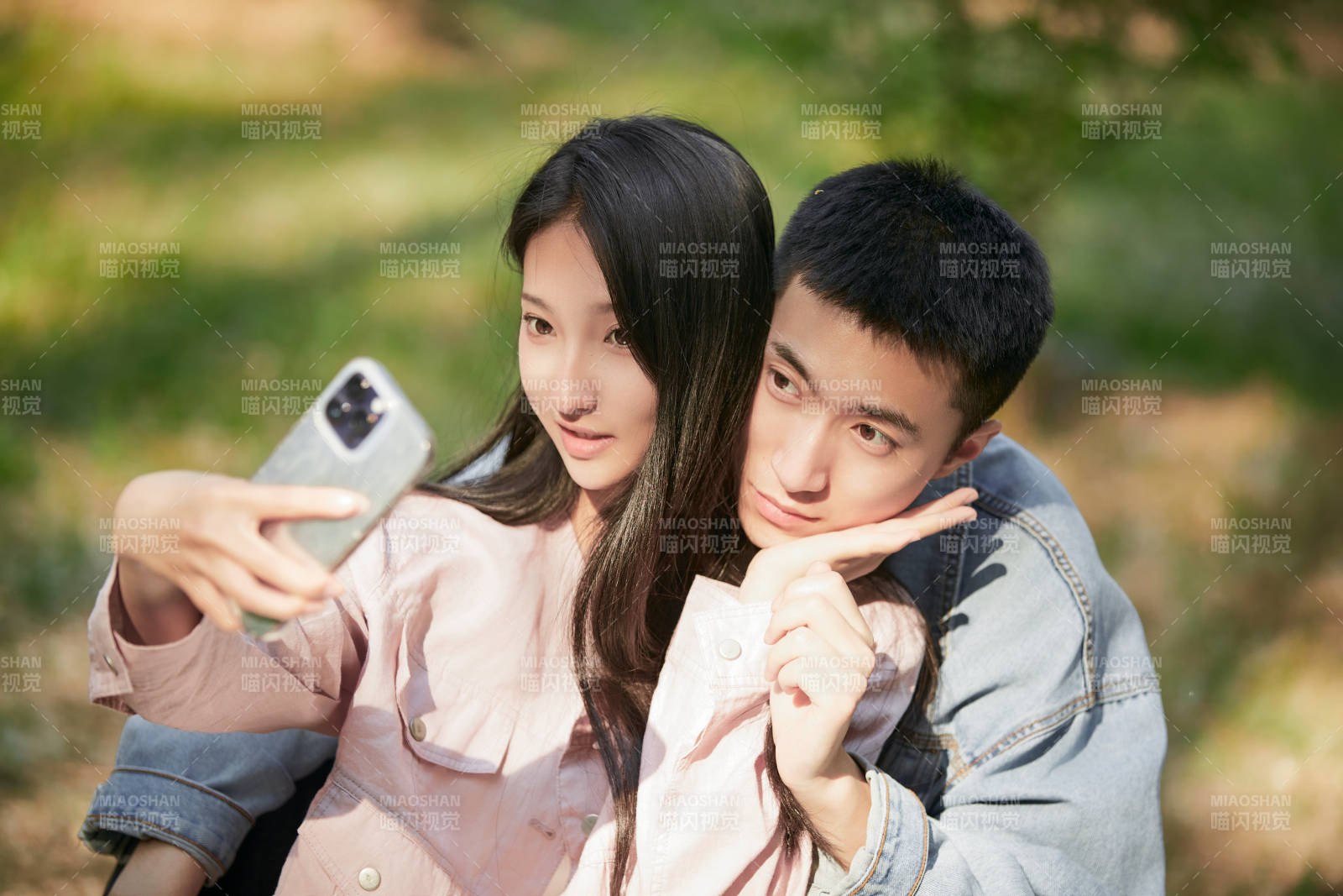 户外公园里用手机自拍的年轻情侣图片