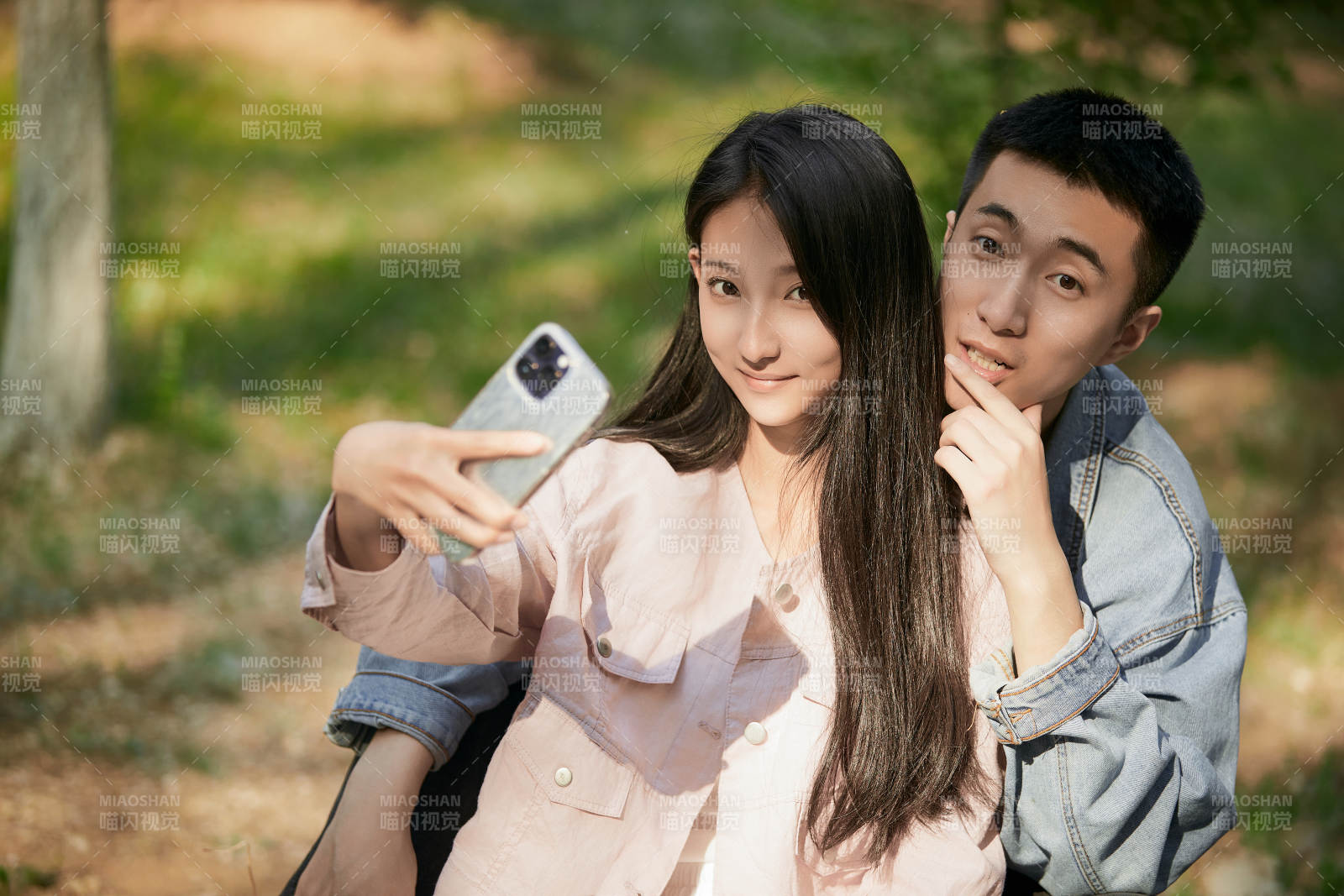 户外公园里用手机自拍的年轻情侣图片
