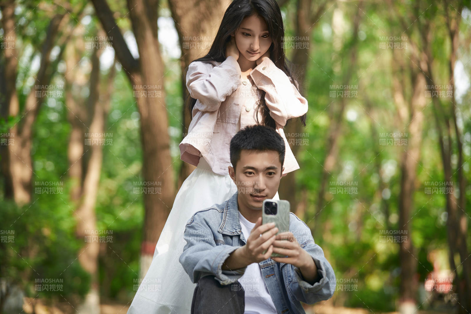 户外公园里用手机自拍的年轻情侣图片