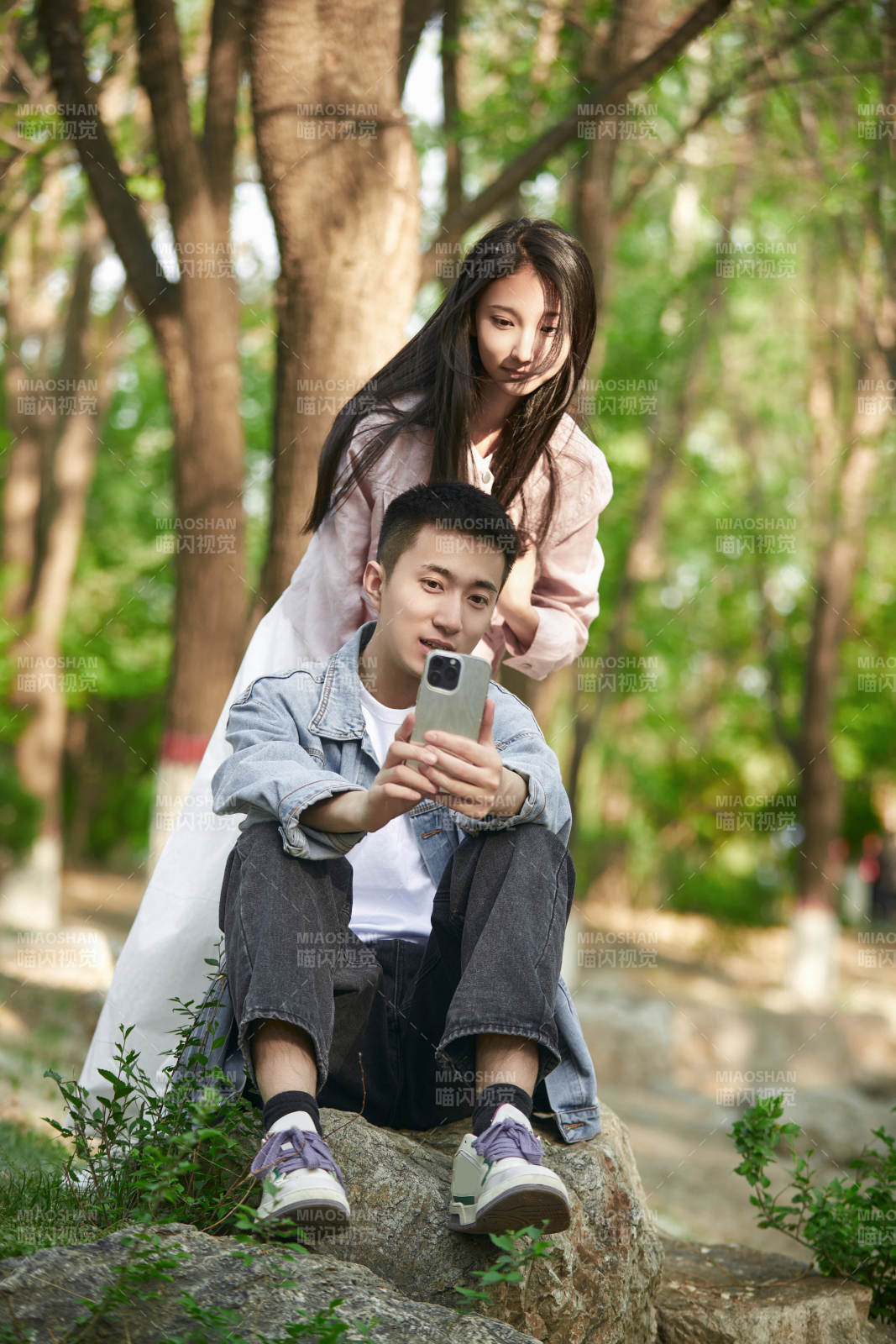 户外公园里用手机自拍的年轻情侣图片