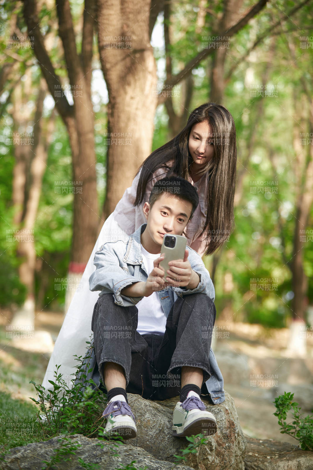 户外公园里用手机自拍的年轻情侣图片