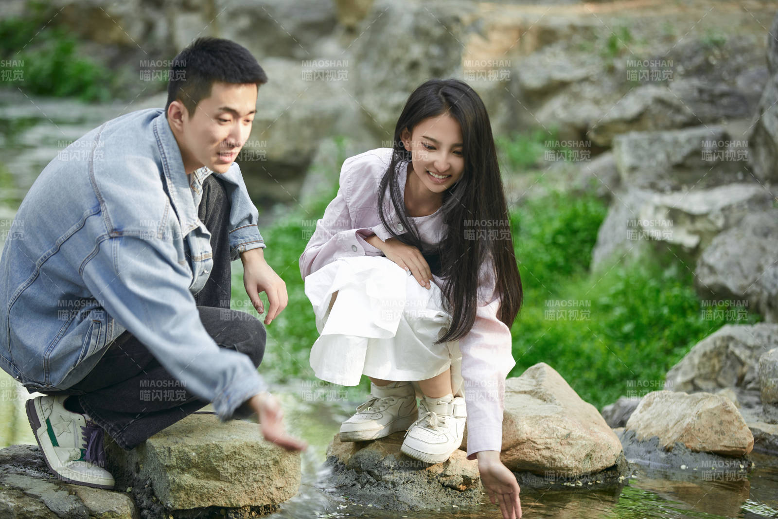 在公园小溪旁嬉戏玩水的青年情侣图片