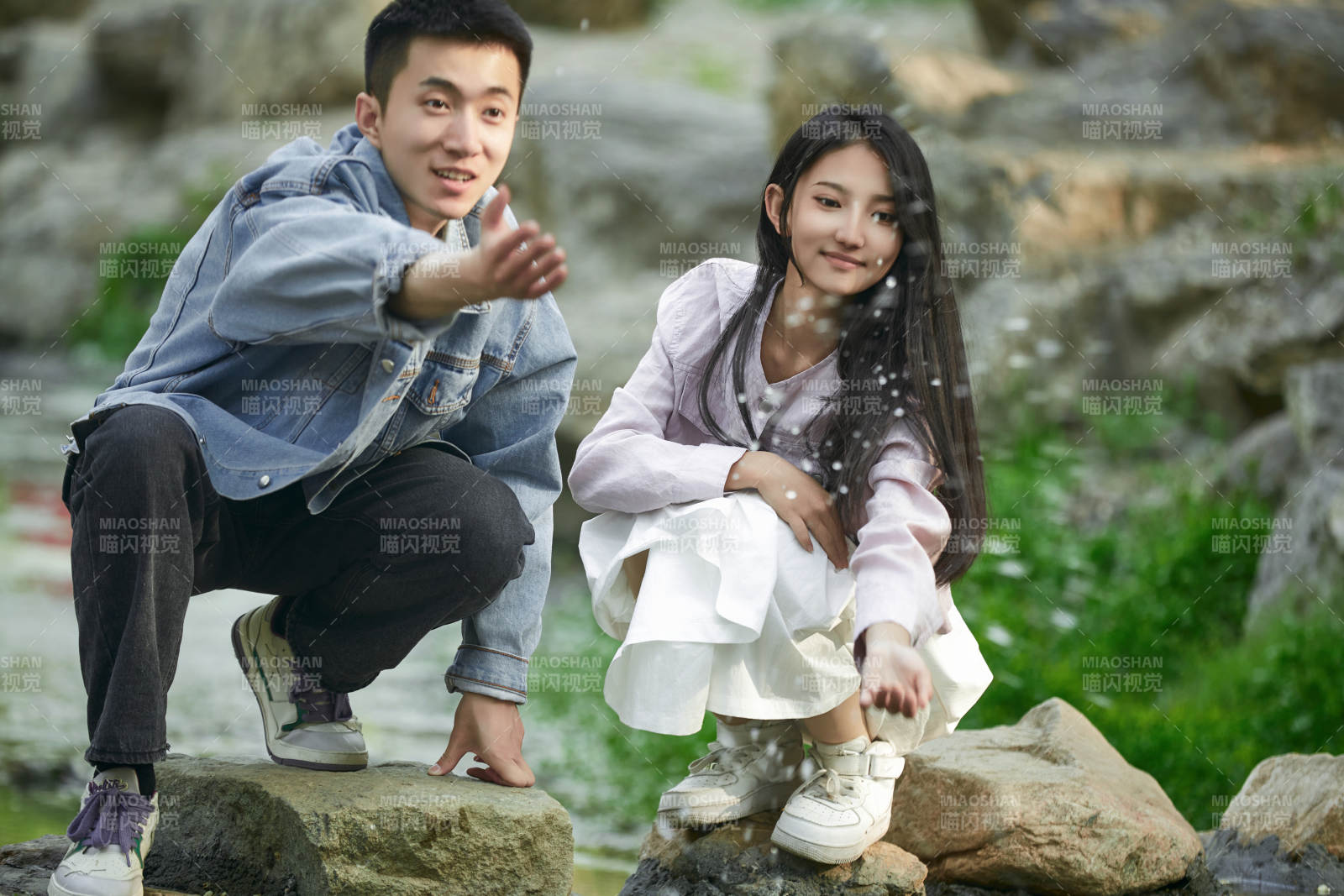 在公园小溪旁嬉戏玩水的青年情侣图片