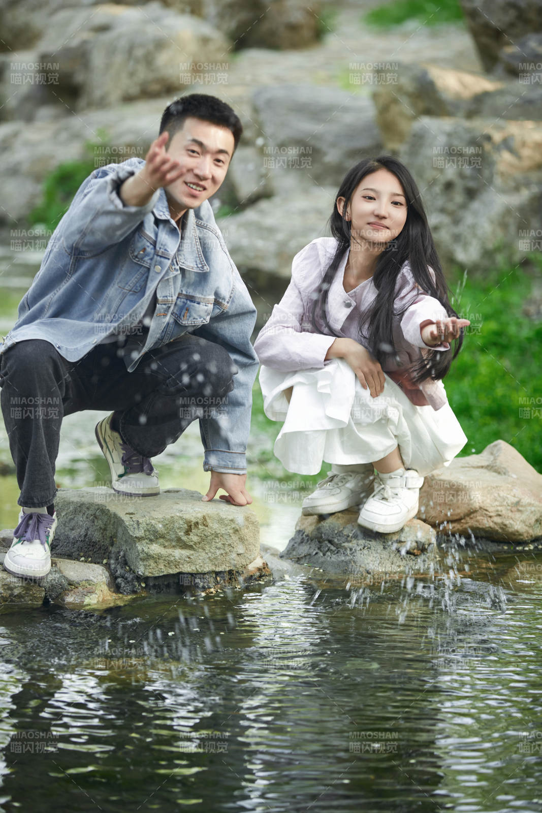 在公园小溪旁嬉戏玩水的青年情侣图片
