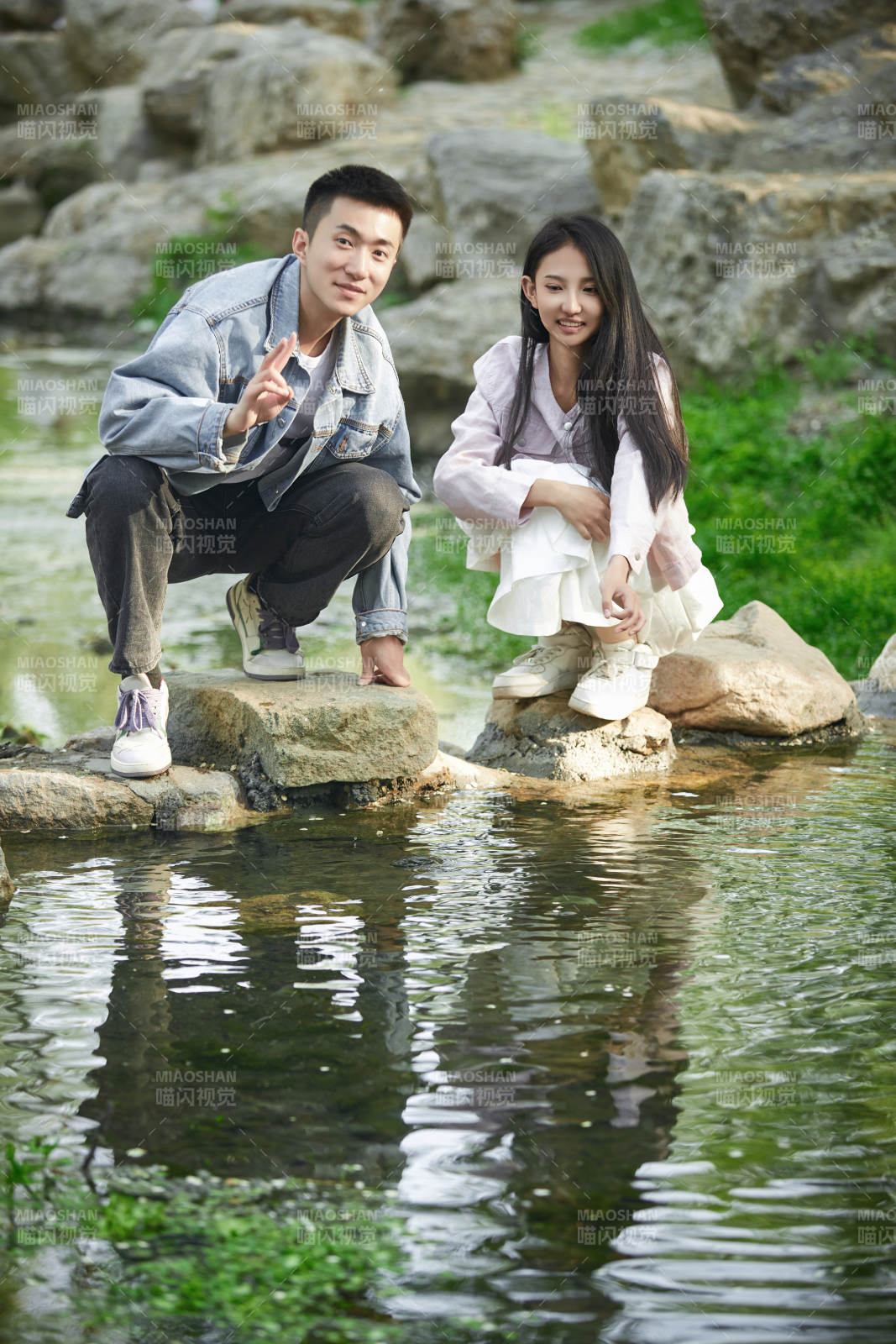 在公园小溪旁嬉戏玩水的青年情侣图片
