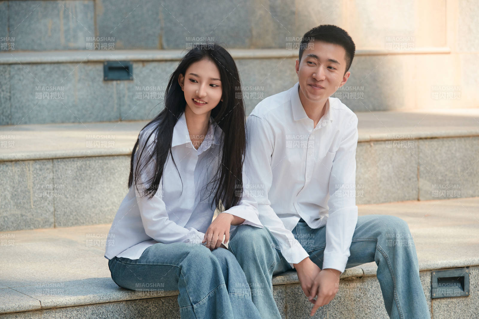坐在户外台阶上的青年情侣图片
