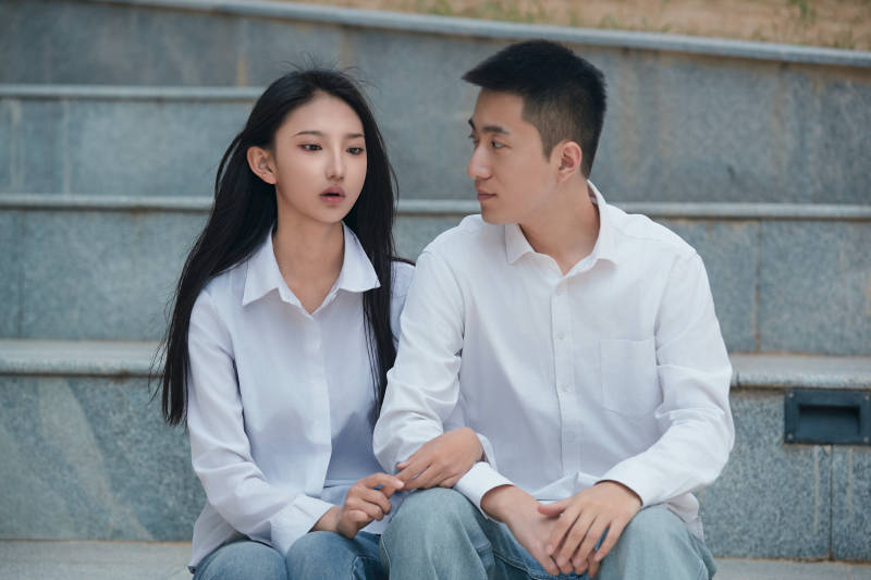 坐在户外台阶上的青年情侣图片