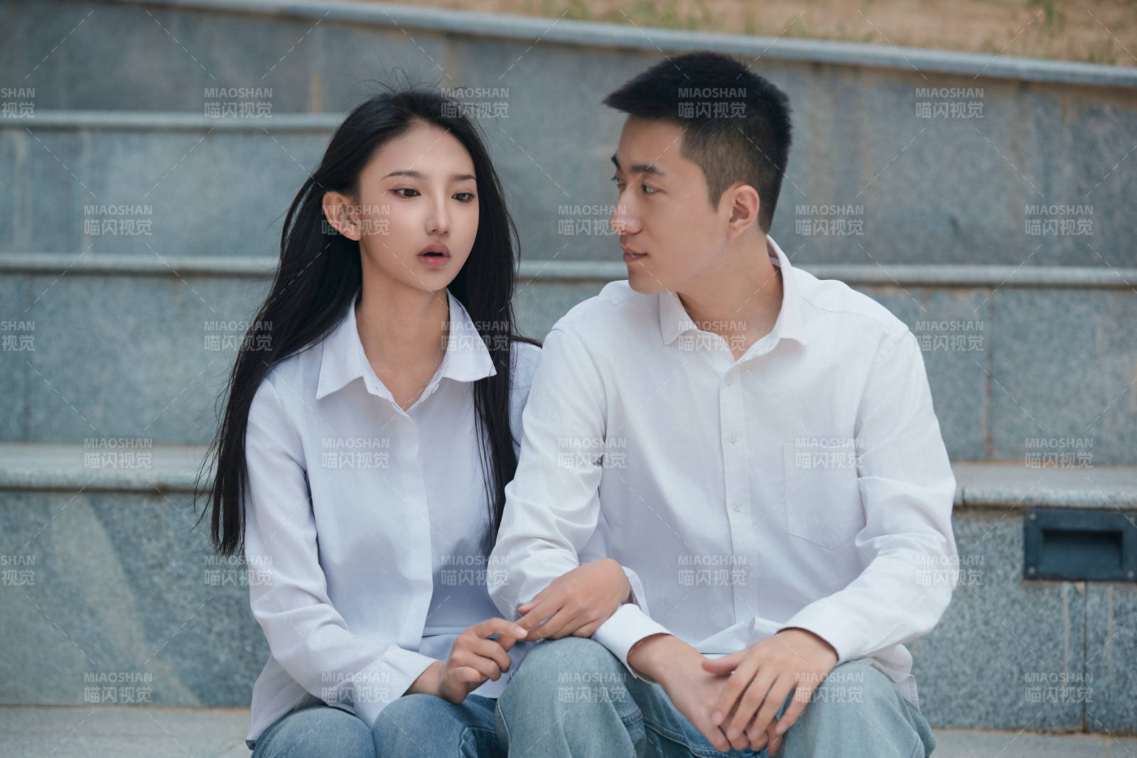 坐在户外台阶上的青年情侣图片