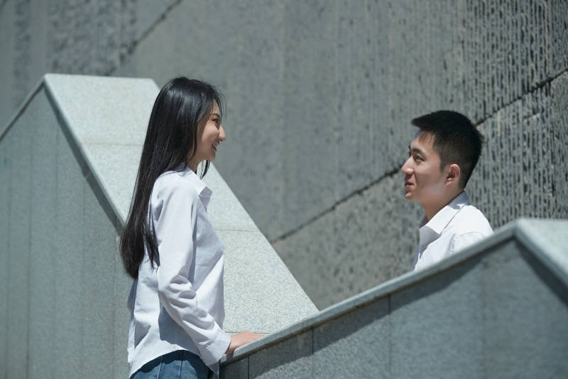 在户外台阶上对视的青年情侣图片