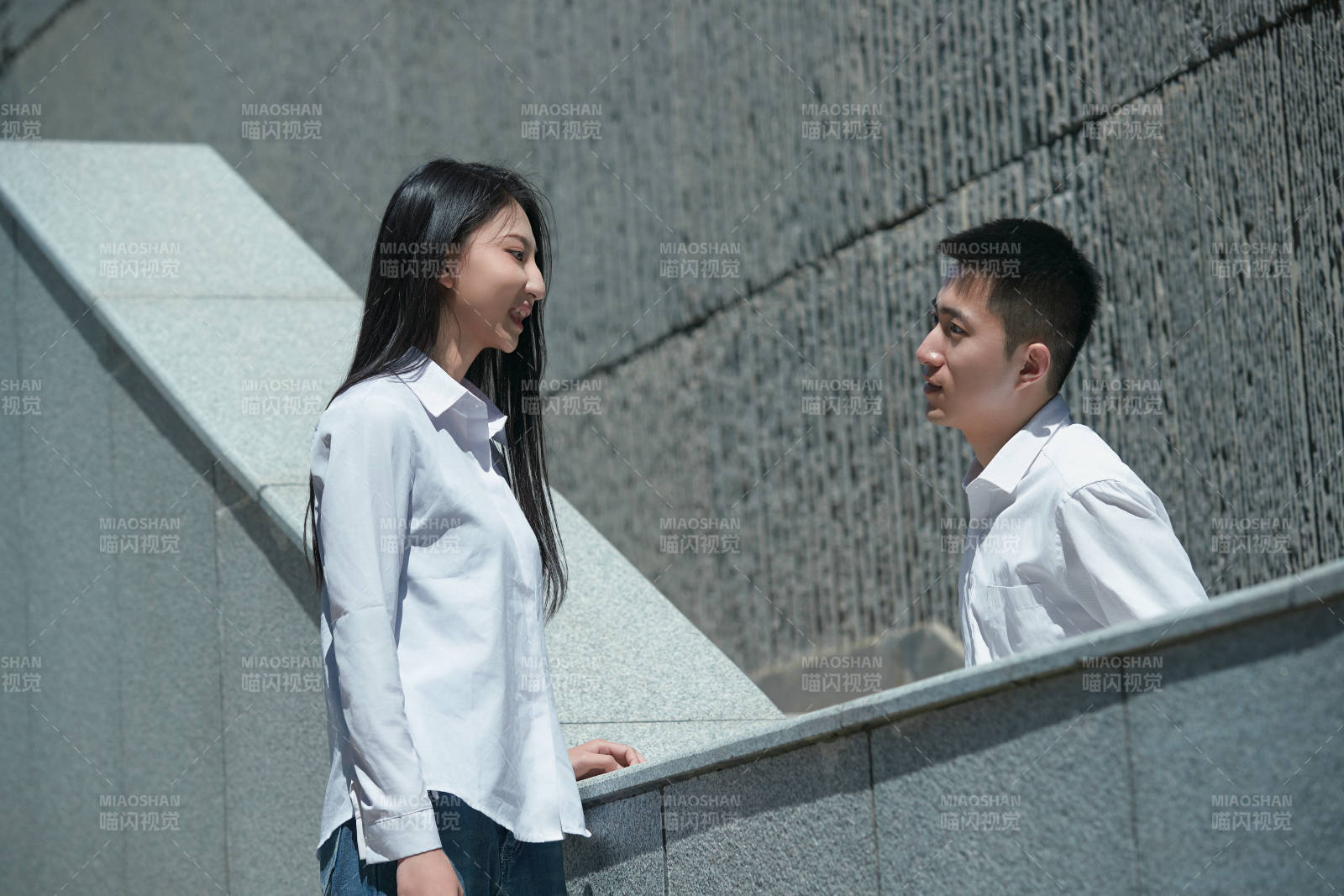 在户外台阶上对视的青年情侣图片