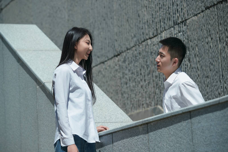 在户外台阶上对视的青年情侣图片