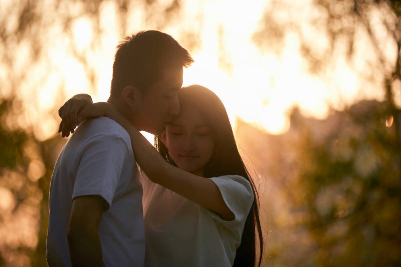 户外在夕阳下的恩爱年轻情侣图片