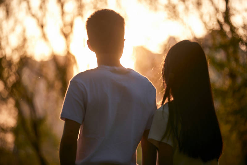 户外在夕阳下的恩爱年轻情侣图片