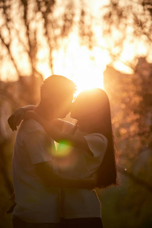户外在夕阳下的恩爱年轻情侣图片