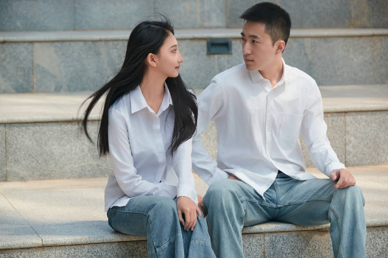 坐在户外台阶上的青年情侣图片