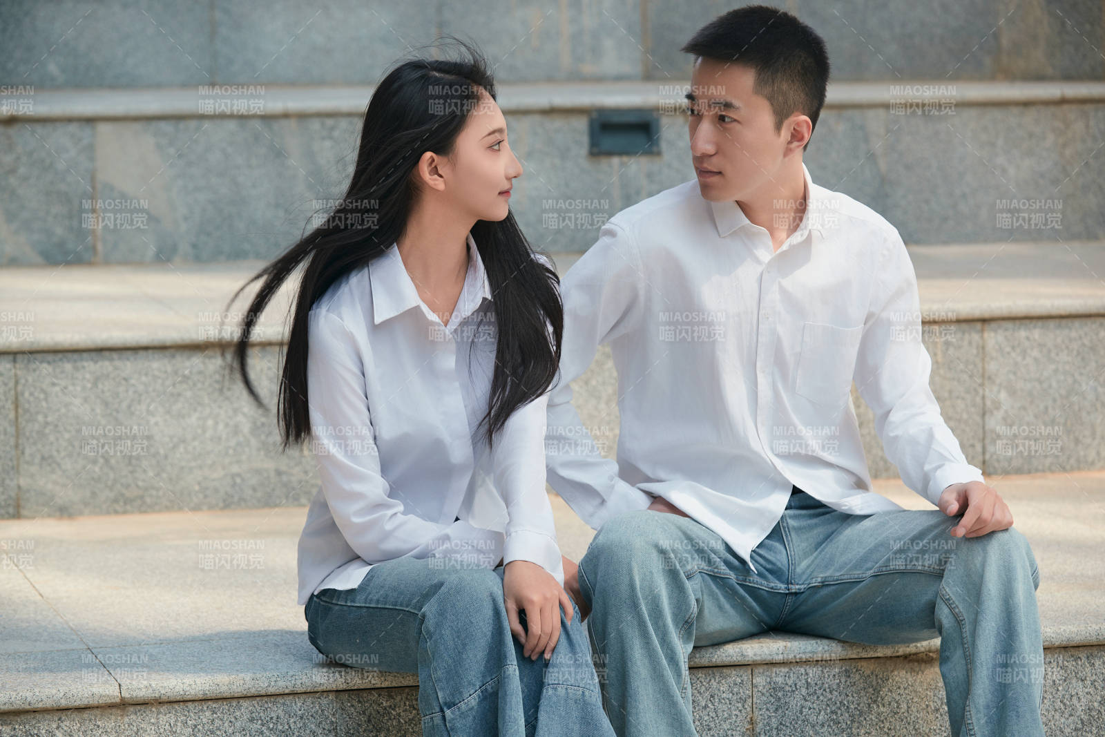 坐在户外台阶上的青年情侣图片