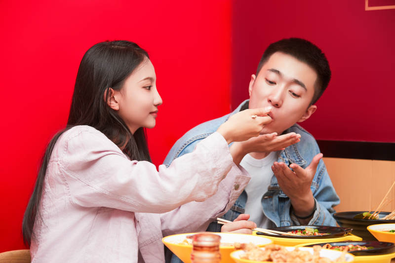 餐厅里吃饭的年轻情侣图片