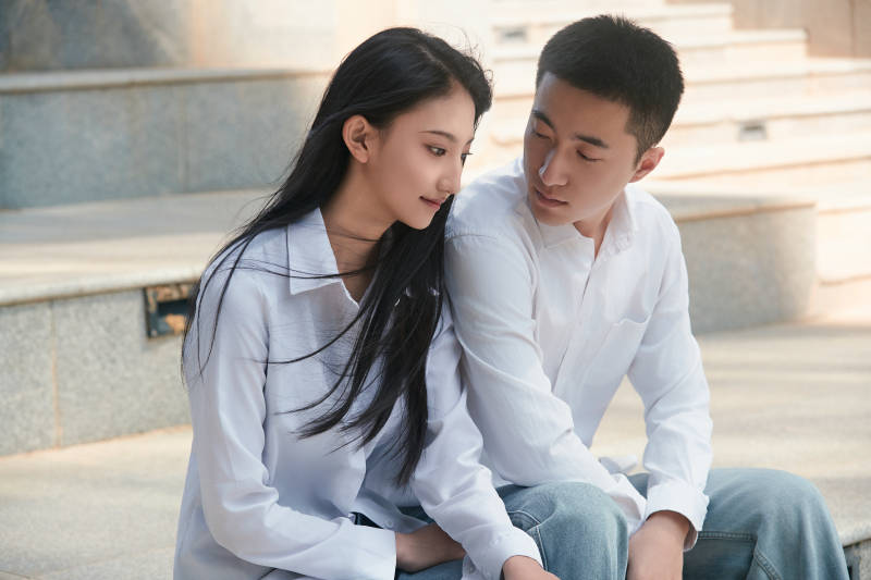 坐在户外台阶上的青年情侣图片