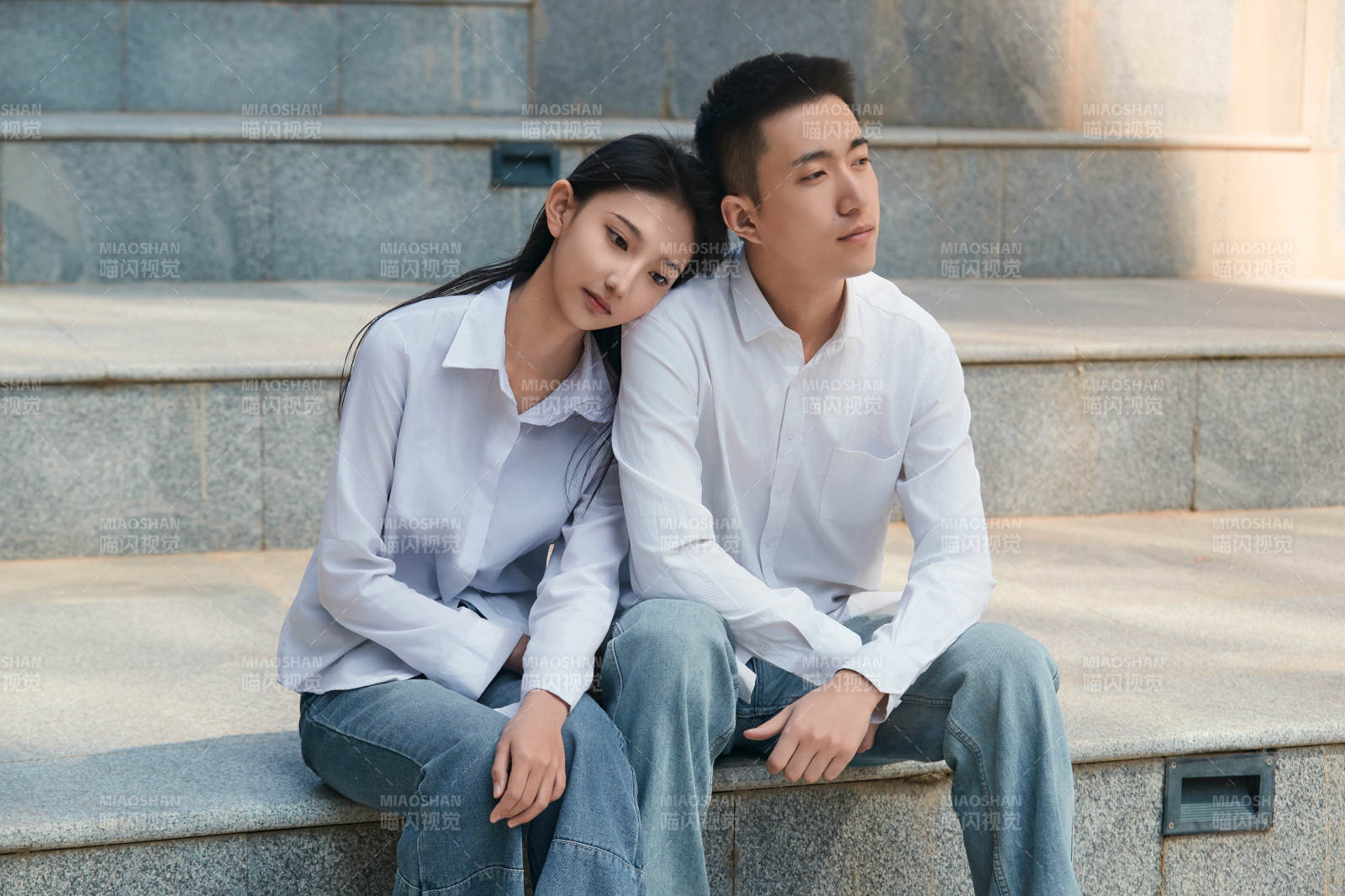 坐在户外台阶上的青年情侣图片