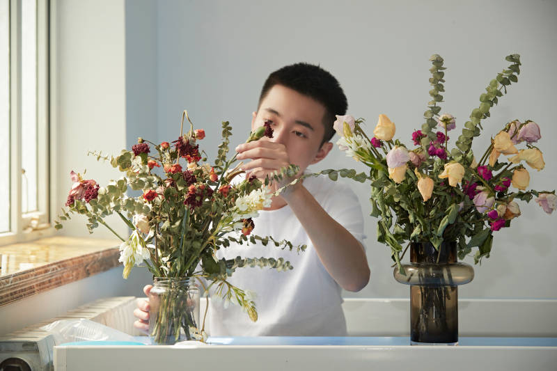 摆弄插花的帅气男青年图片