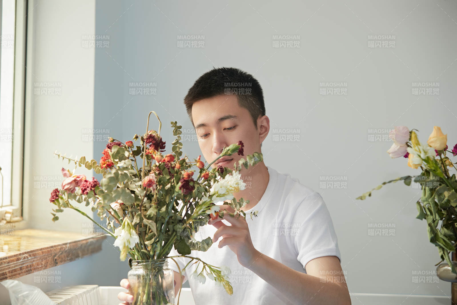 摆弄插花的帅气男青年图片