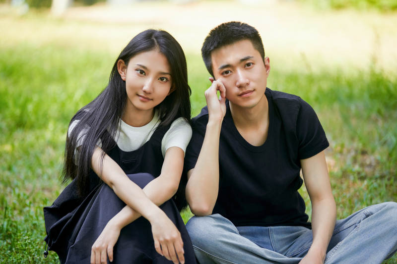 户外草坪上的恩爱年轻情侣图片