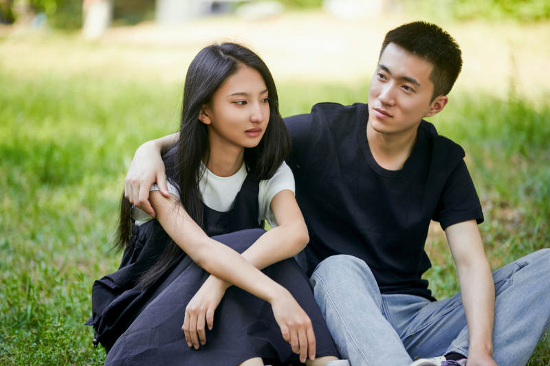 户外草坪上的恩爱年轻情侣图片