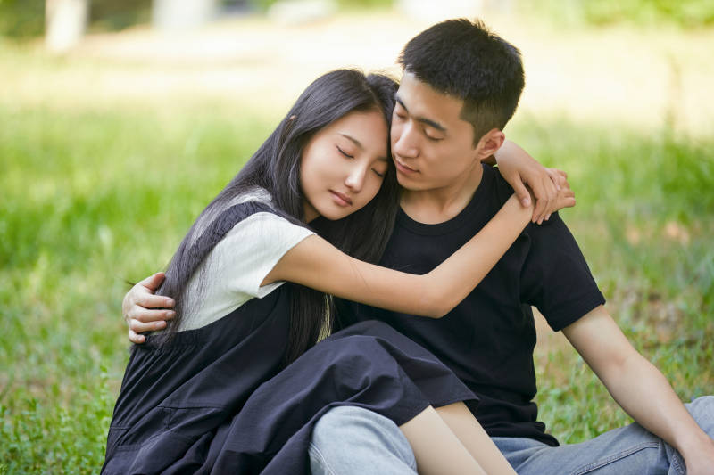 户外草坪上的恩爱年轻情侣图片