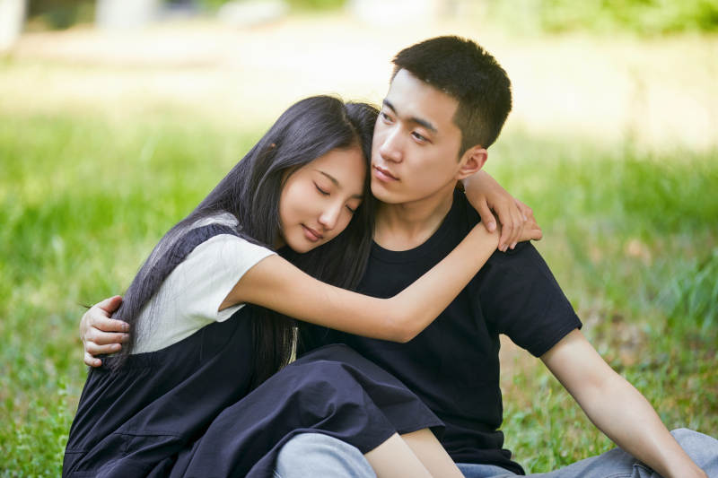 户外草坪上的恩爱年轻情侣图片